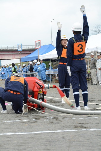市防災総合訓練の参加者の前で小型ポンプ操法を披露する桃山方面隊のメンバーの写真3
