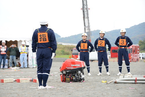 市防災総合訓練の参加者の前で小型ポンプ操法を披露する桃山方面隊のメンバーの写真2