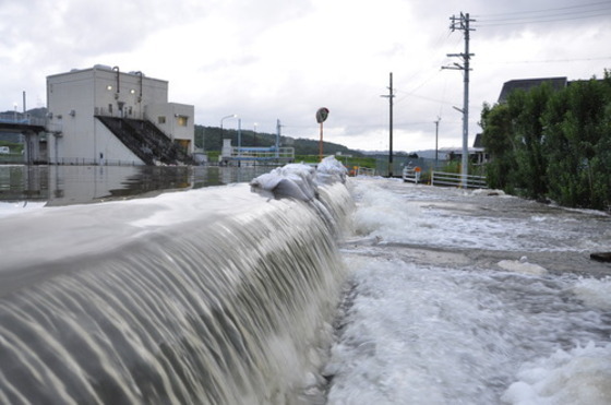 桃山町調月地区（宮の前排水機場）の水路から市道に水があふれる写真