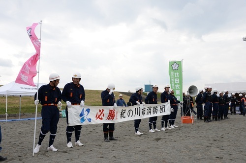 市防災総合訓練の参加者の前で小型ポンプ操法を披露する桃山方面隊のメンバーの写真1