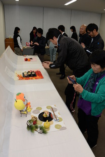 フルーツ寿司を撮影する参加者たちの写真