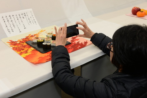 フルーツ寿司を撮影する参加者の写真